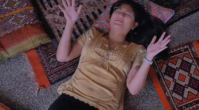 a woman laying on the floor with her hands in the air