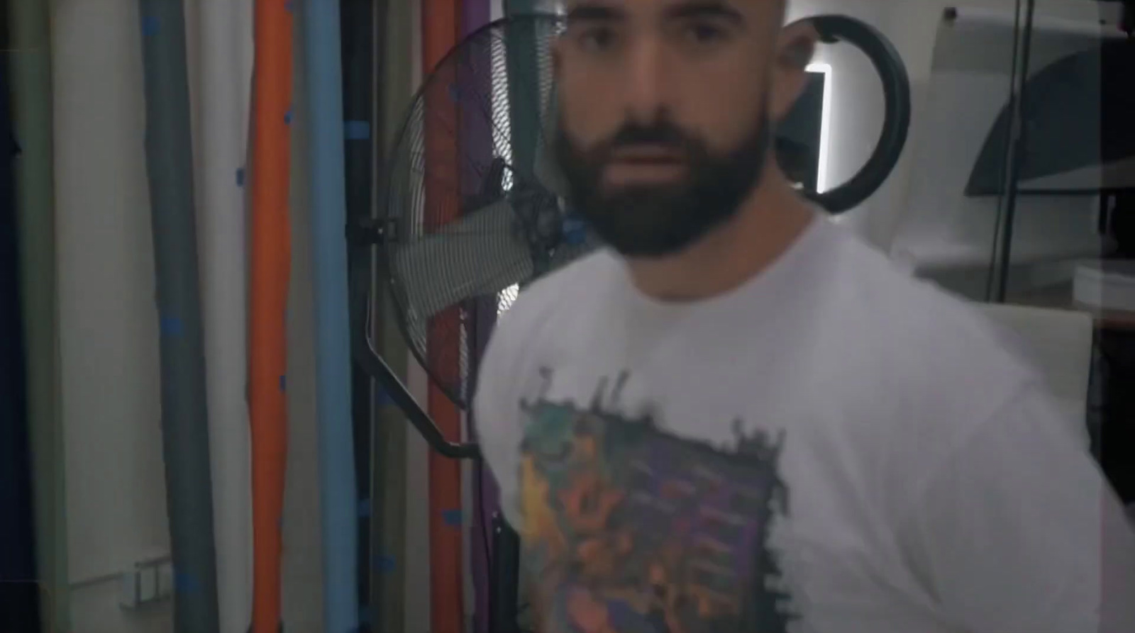 a man with a beard standing in front of a racket