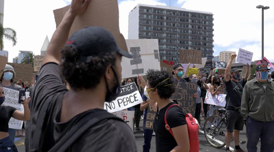 a group of people holding signs and standing in the street