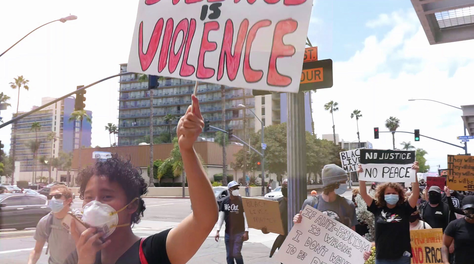 a group of people holding up signs on a city street