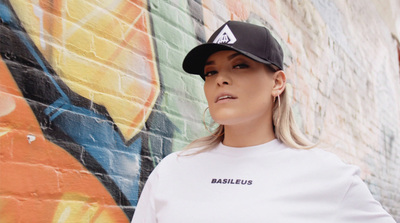 a woman standing in front of a graffiti wall