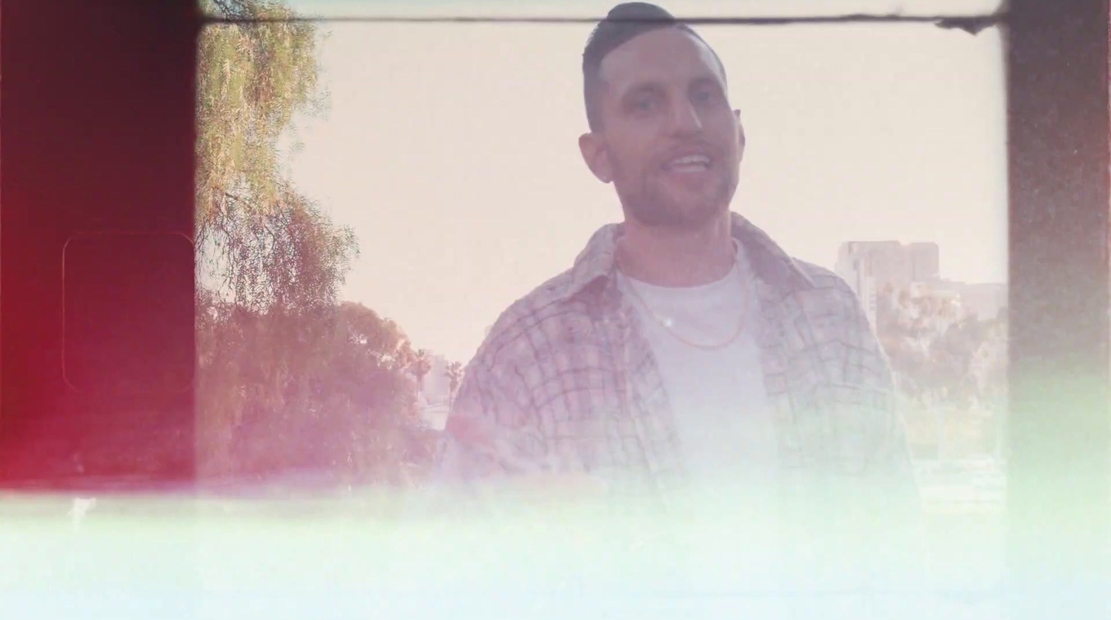 a man standing in front of a window with trees in the background