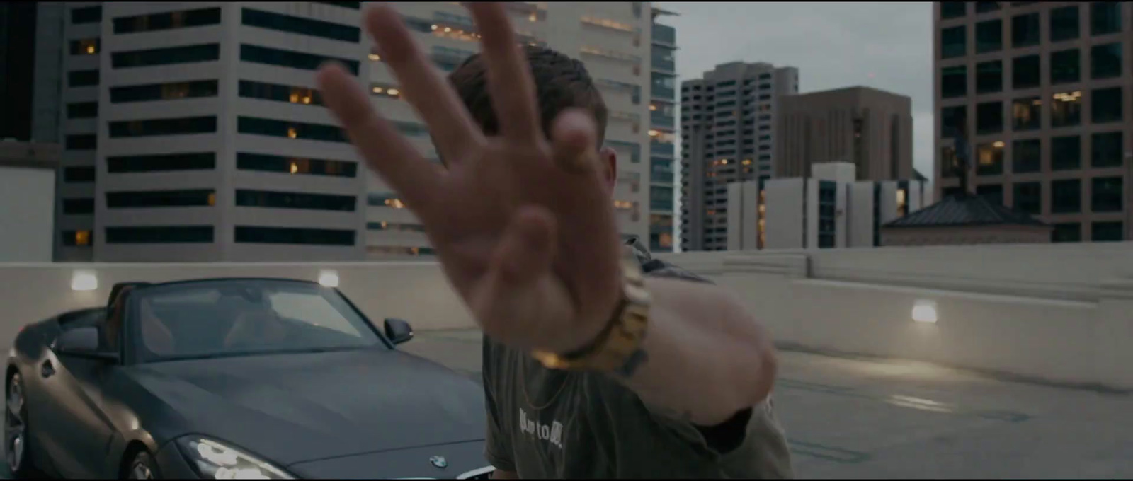 a man holding his hand up in front of a car