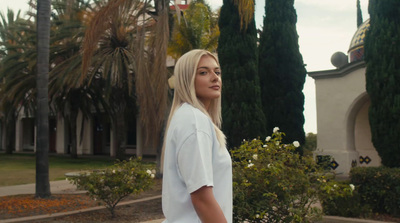 a woman with blonde hair standing in front of a building