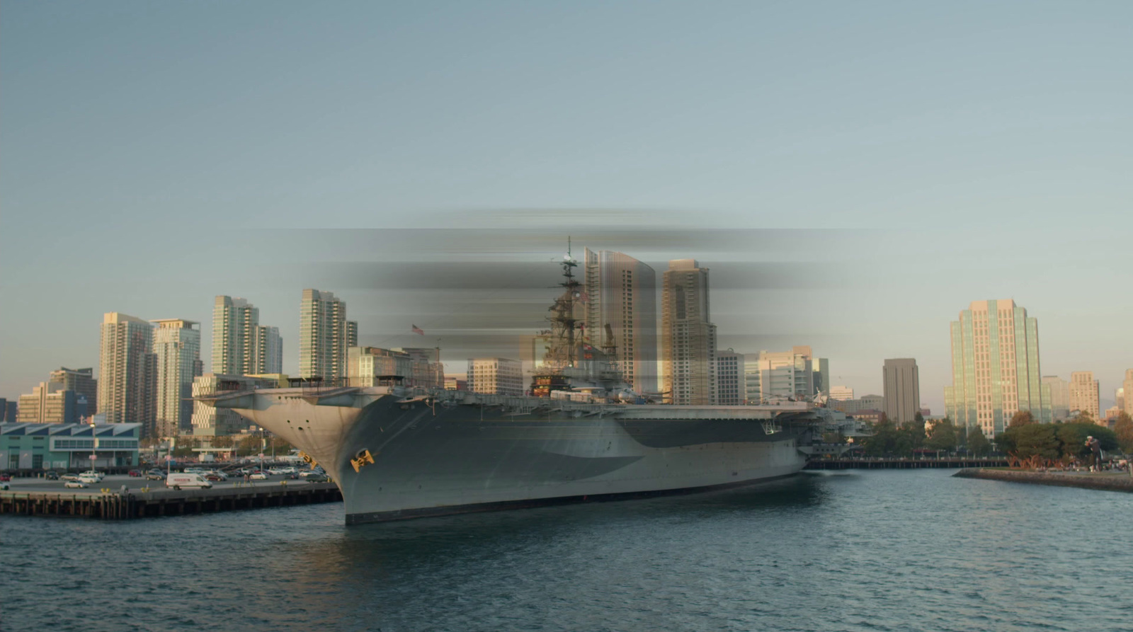 a large ship in the water with a city in the background