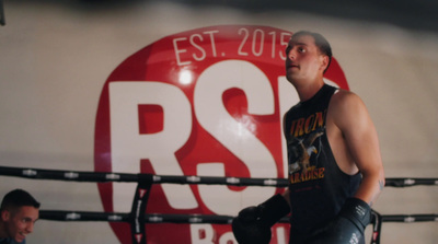 a man standing next to a boxing ring