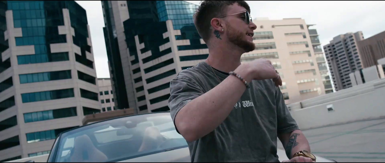 a man with a watch on his left hand is standing in front of a car