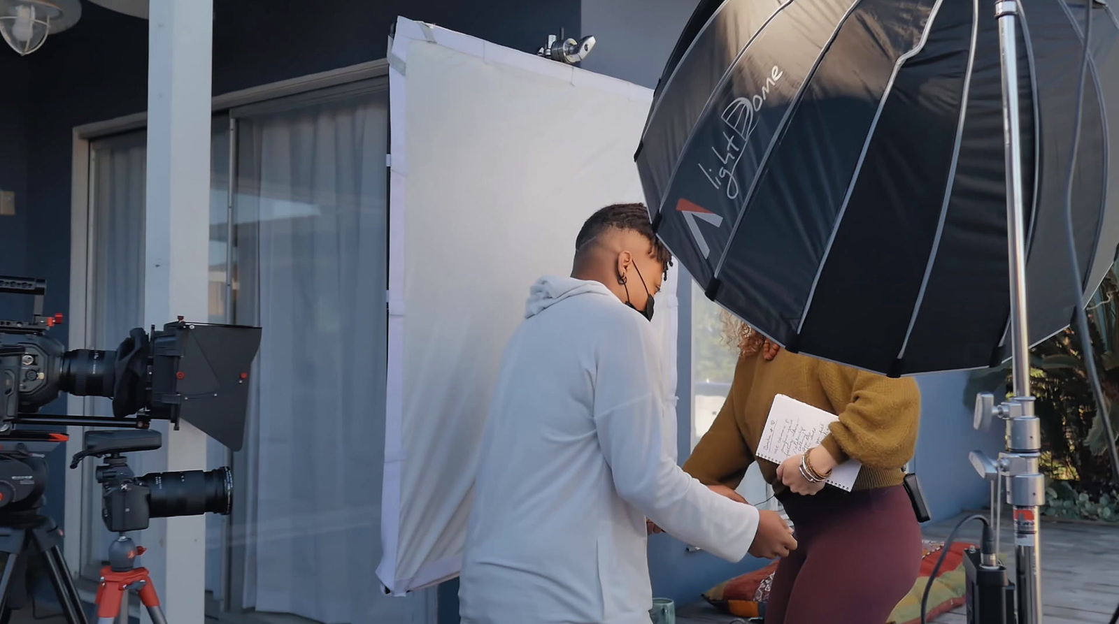 a man standing next to a woman holding an umbrella