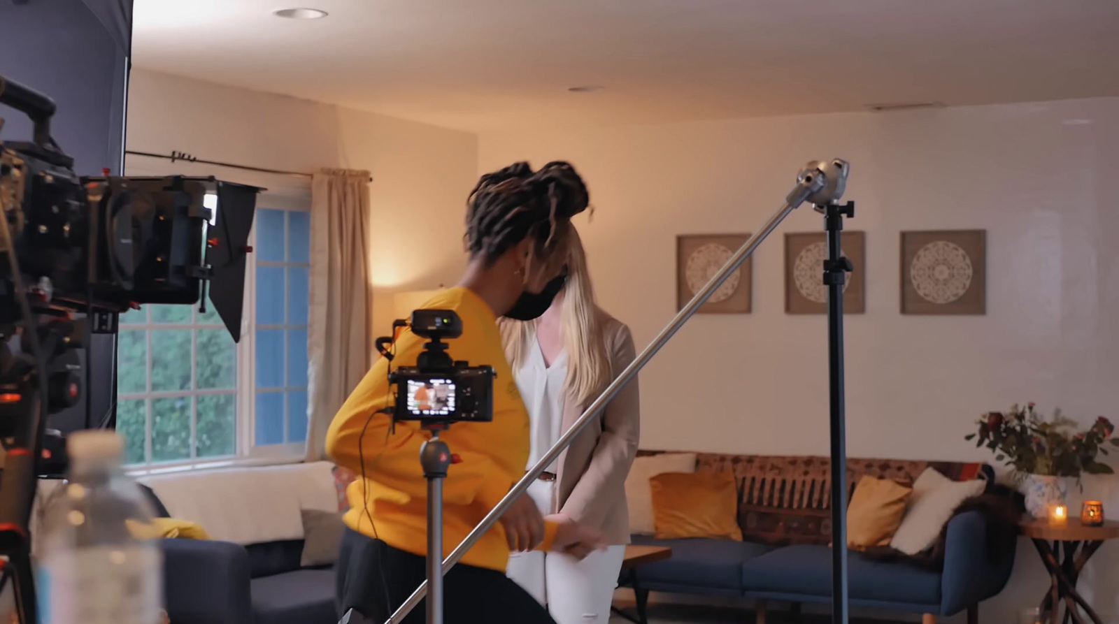 a woman standing in a living room next to a camera