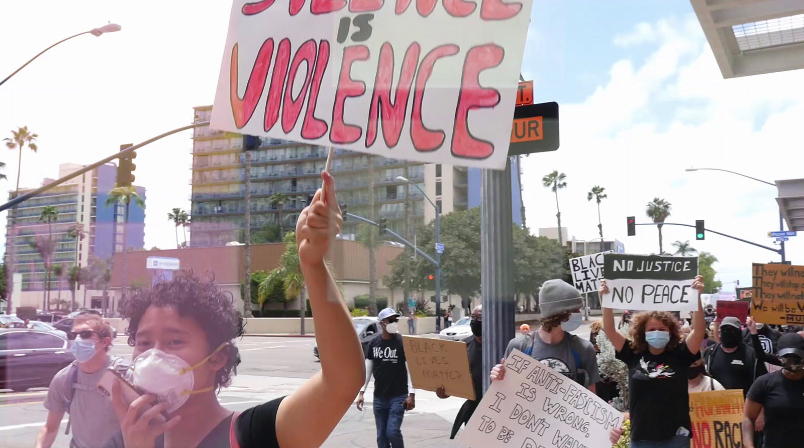 a group of people holding up signs on a city street