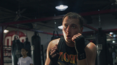 a man standing in a gym holding a boxing glove