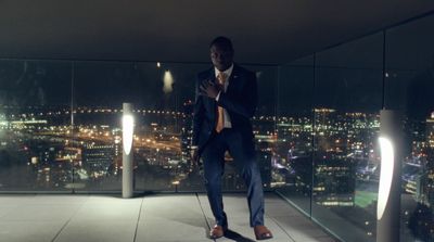 a man in a suit and tie standing in front of a window