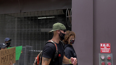 a man wearing a face mask walking down a street