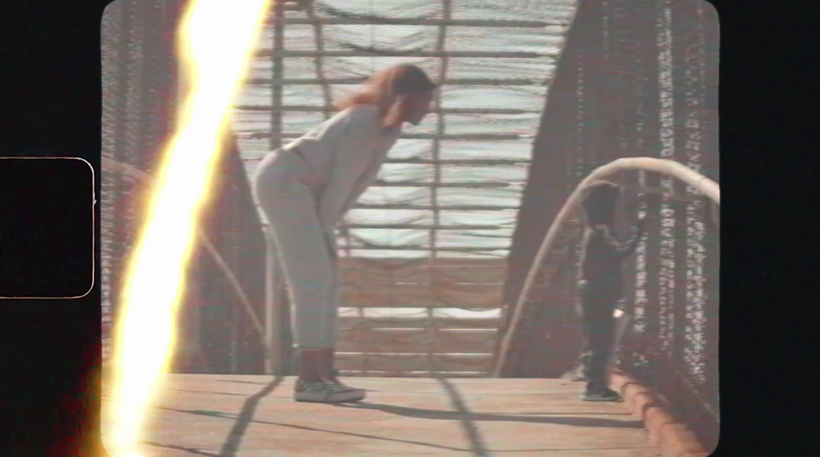 a woman is standing on a bridge with her back to the camera