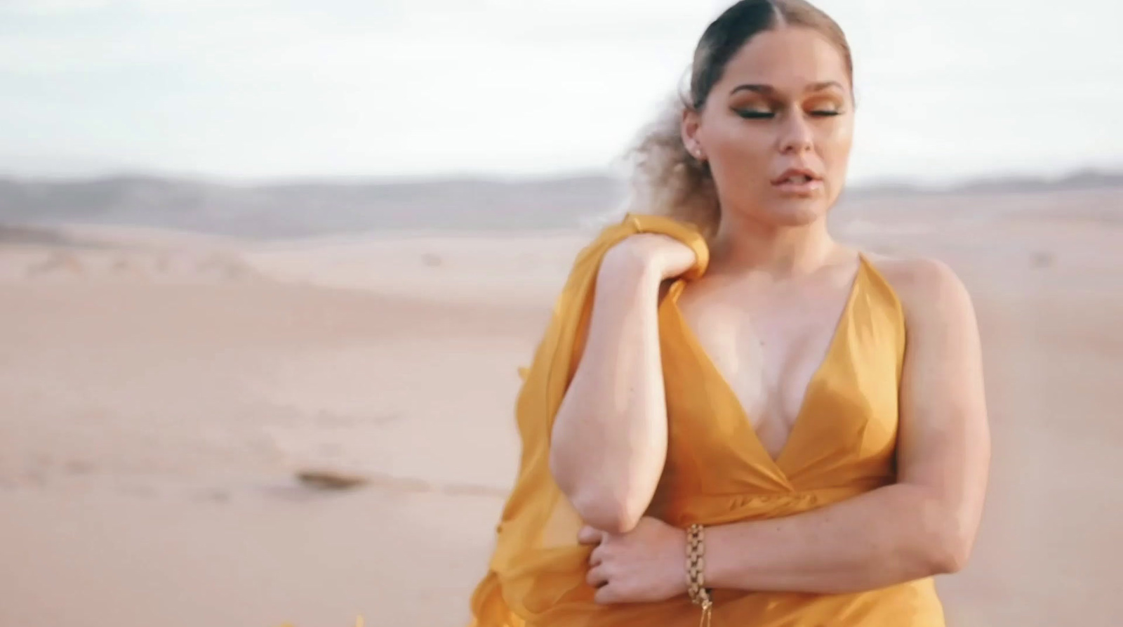 a woman in a yellow dress standing in the desert