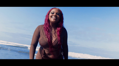 a woman with red hair is standing on the beach