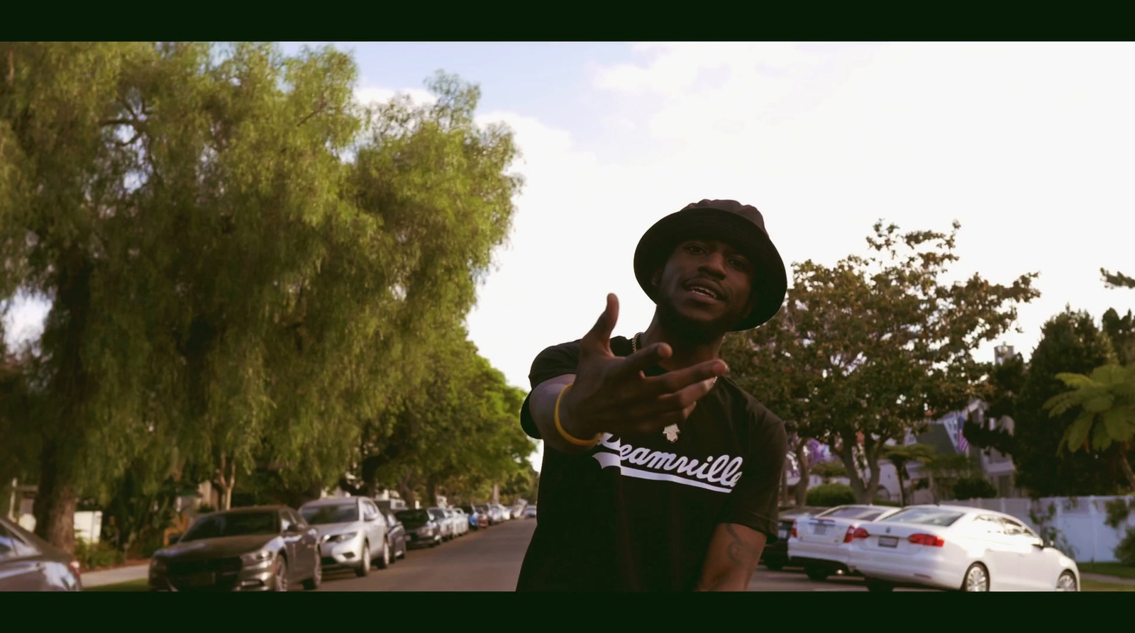 a man in a black hoodie pointing at the camera