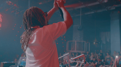 a man with dreadlocks standing in front of a crowd