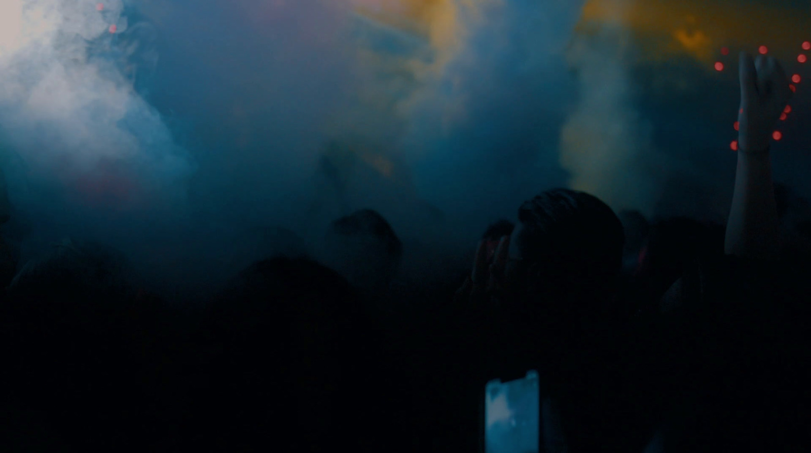 a crowd of people at a concert with their hands in the air