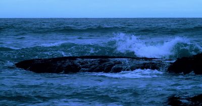 a large body of water with waves crashing on top of it