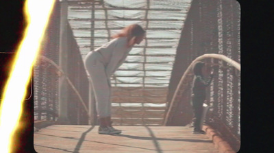 a woman standing on a bridge with her hands on her hips