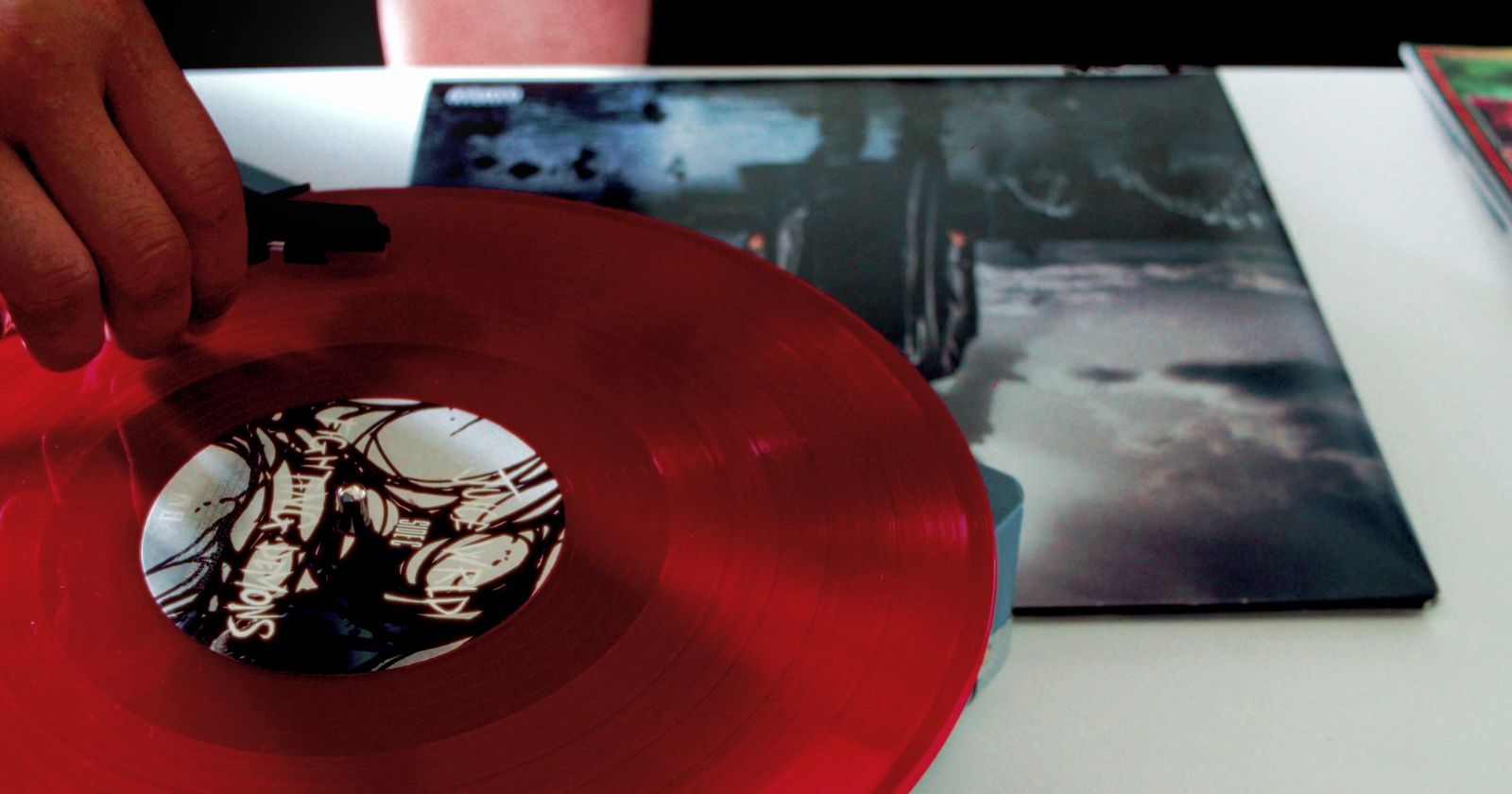 a person holding a red vinyl record in their hand