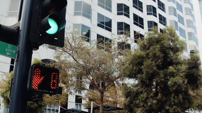 a green traffic light sitting next to a tall building