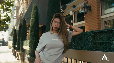 a woman leaning against a fence in front of a building