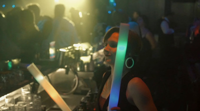 a woman holding a pair of headphones at a party