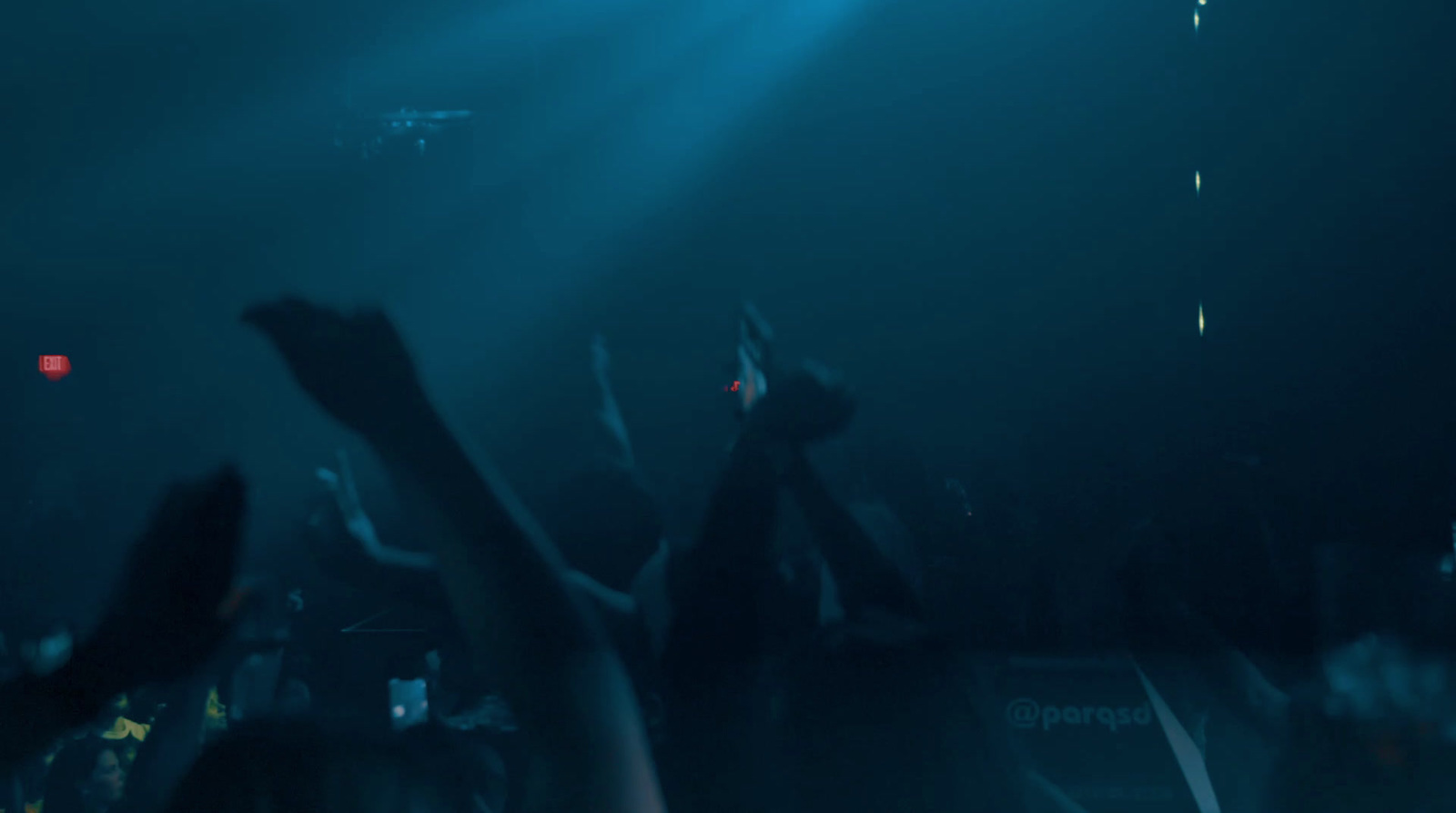 a crowd of people at a concert with their hands in the air