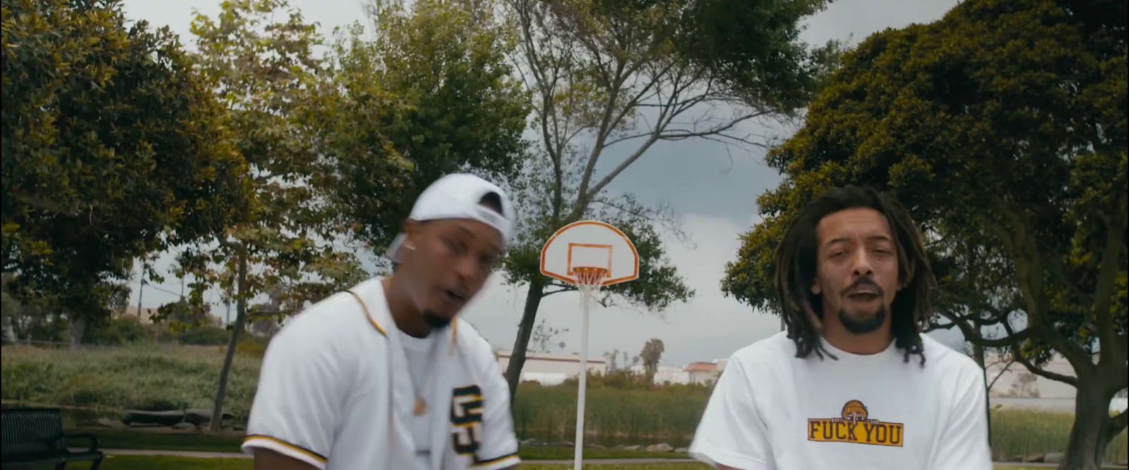 two men standing next to each other near a basketball hoop