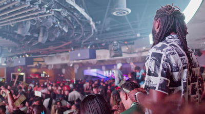 a man with dreadlocks standing in front of a crowd of people