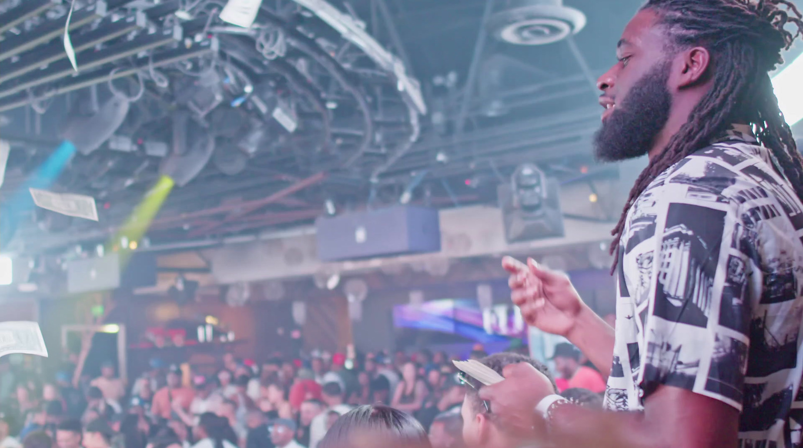 a man with dreadlocks standing in front of a crowd