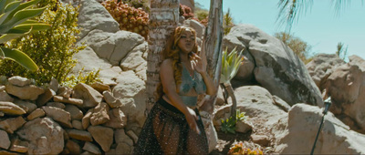 a woman standing next to a palm tree