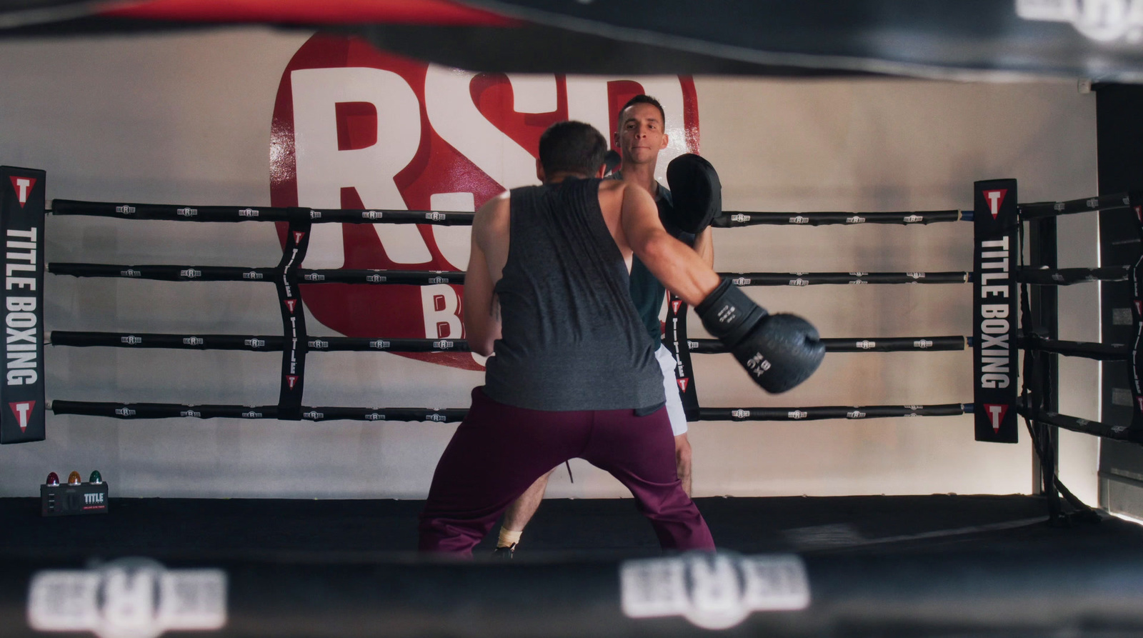 a couple of men standing next to each other in a boxing ring