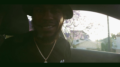 a man sitting in a car wearing a hat