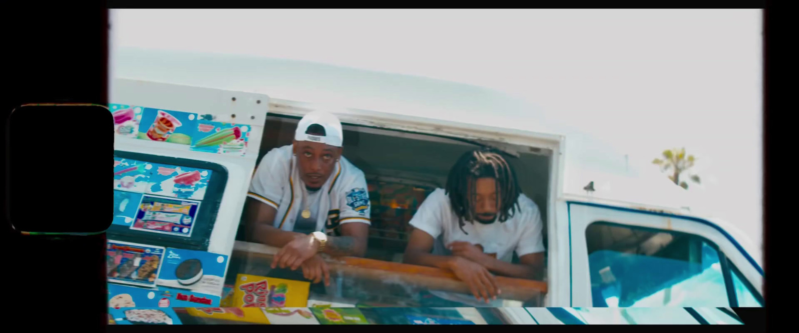 two men sitting in the back of a food truck