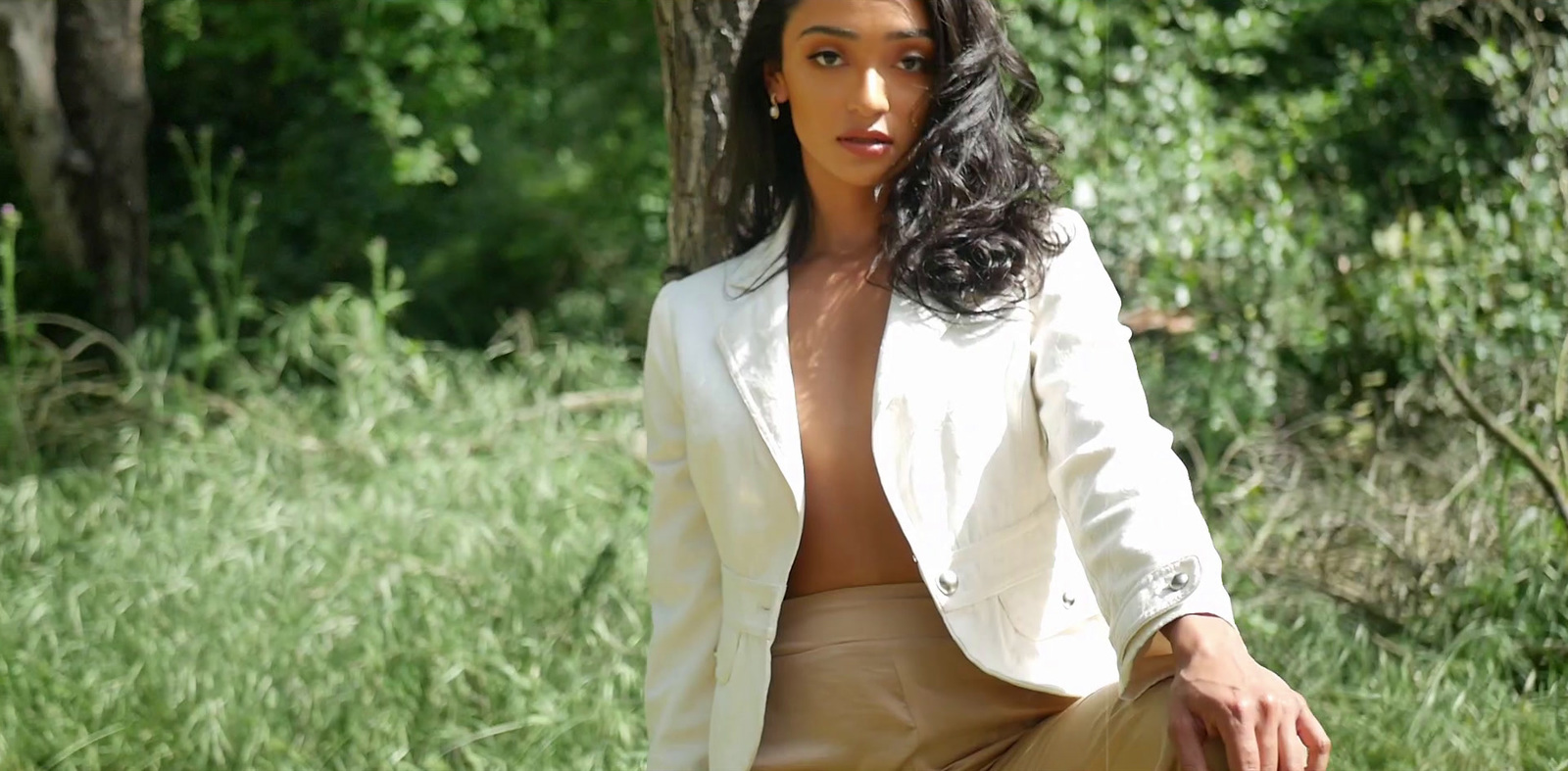 a woman in a white jacket and tan pants