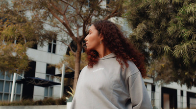 a woman standing in front of a building holding a frisbee