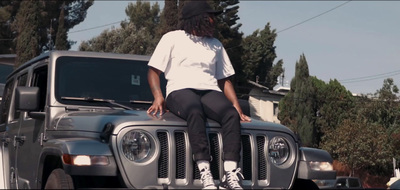 a woman sitting on the hood of a jeep