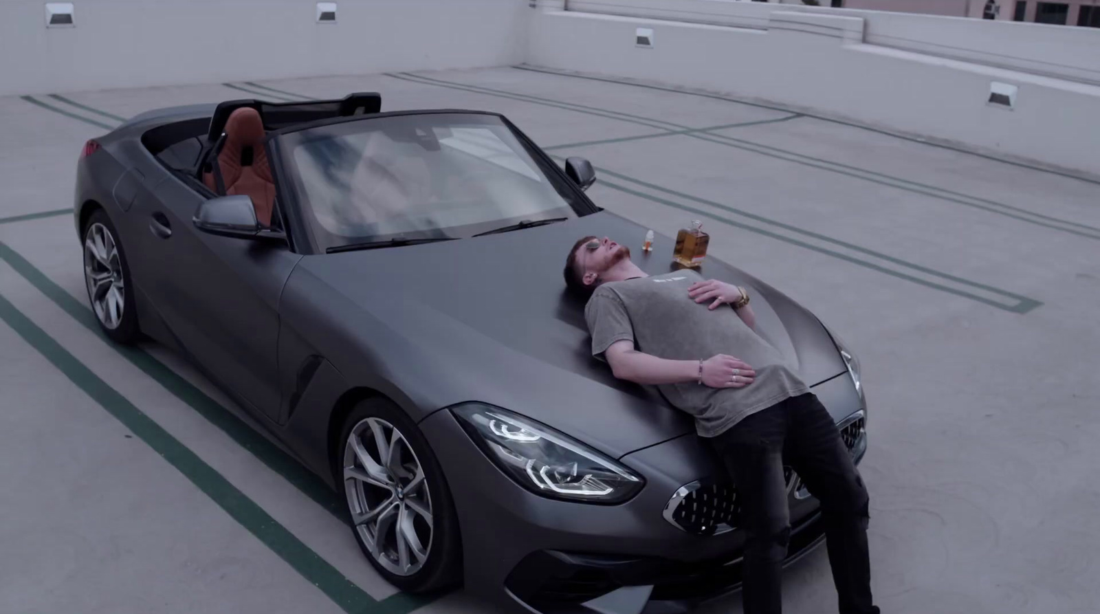 a man laying on the hood of a sports car