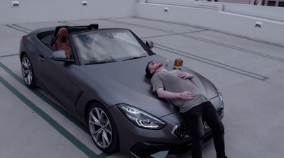 a man laying on the hood of a sports car