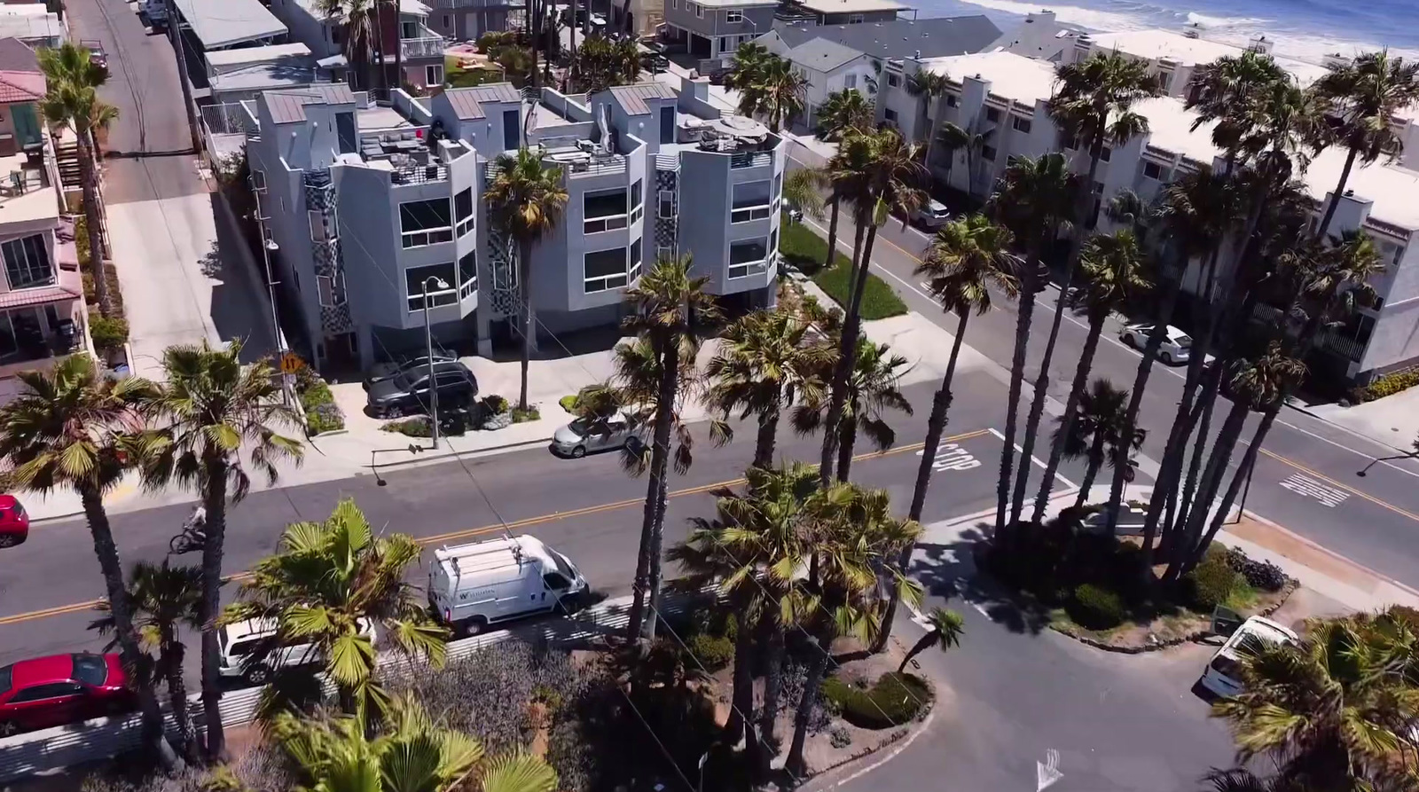 an aerial view of a street with palm trees