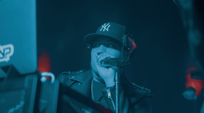 a man with a hat on singing into a microphone