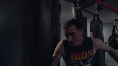 a man standing in a gym with a punching bag