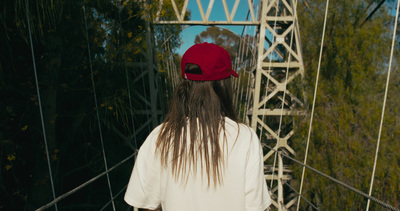 a person with long hair walking across a bridge