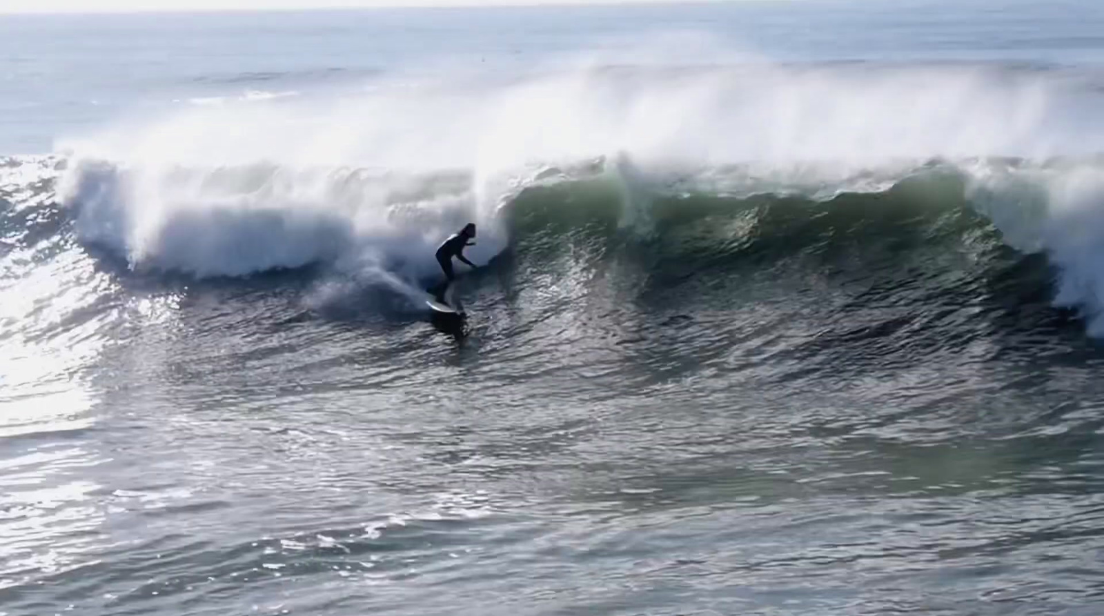 a man riding a wave on top of a surfboard