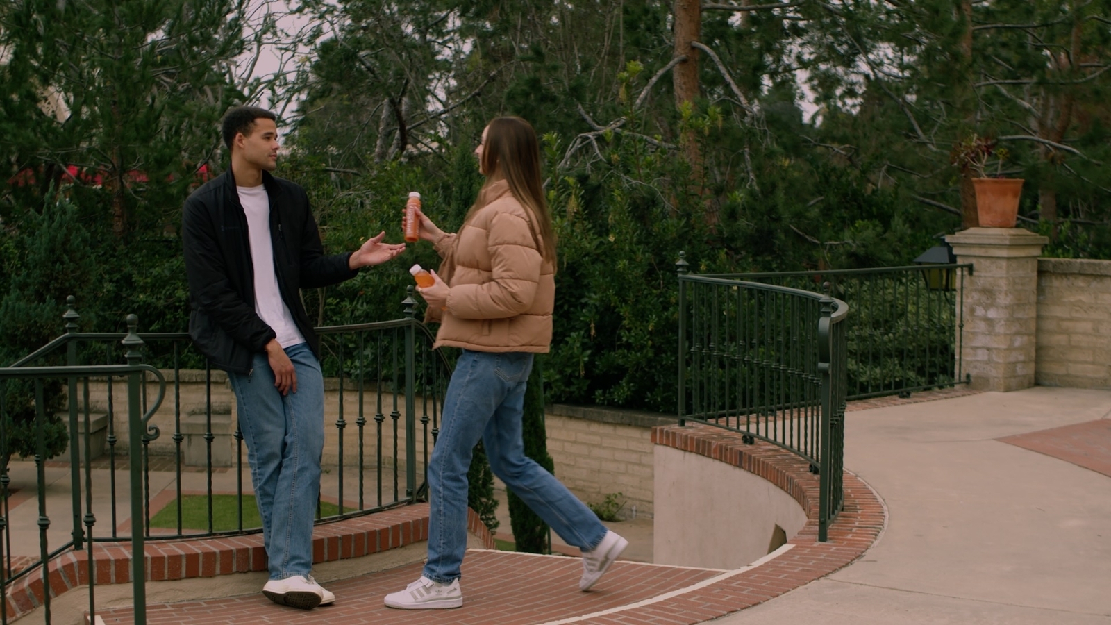 a man standing next to a woman on top of a sidewalk