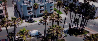 an aerial view of a city street with palm trees