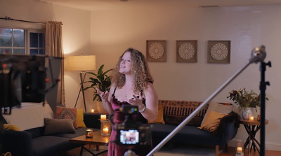 a woman standing in a living room holding a camera